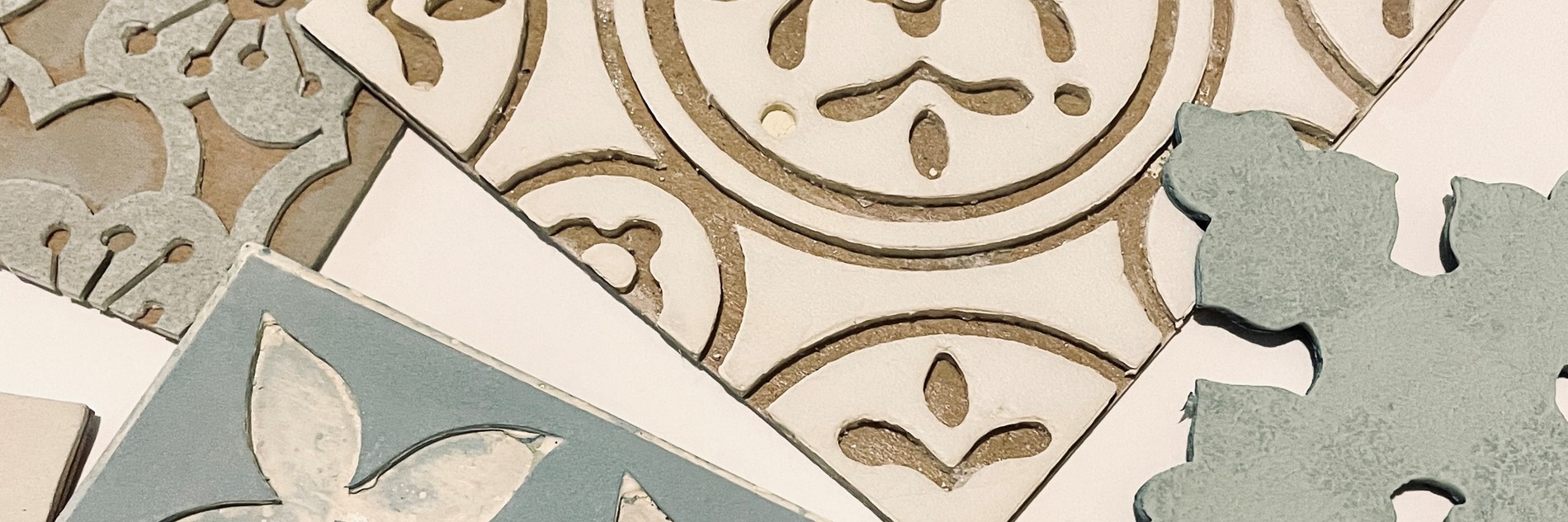 A selection of hand-block printing tiles, they're square shaped with graphic floral patterns.