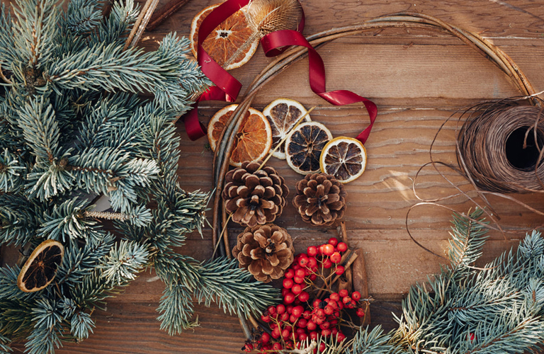 A photograph of wreath-making materials, including orange slices, twine and berries.