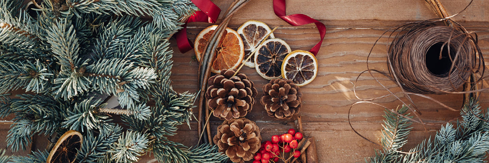 A photograph of wreath-making materials, including orange slices, twine and berries.