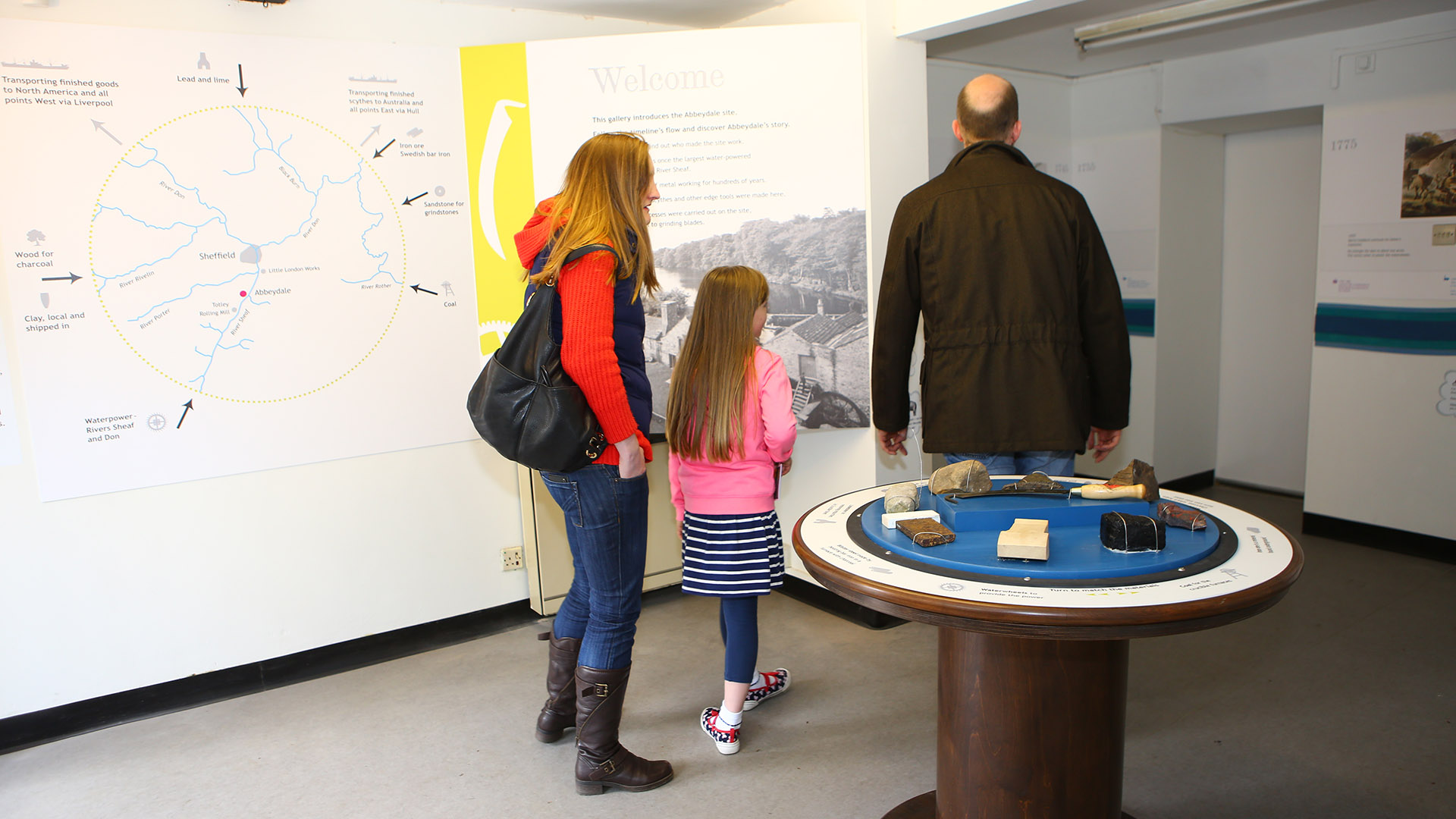 Two adults and a child viewing displays in the museum.