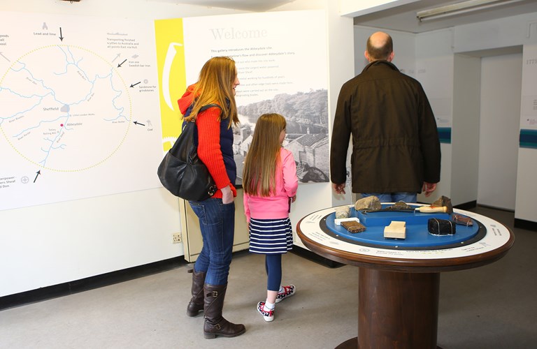 Two adults and a child viewing displays in the museum.