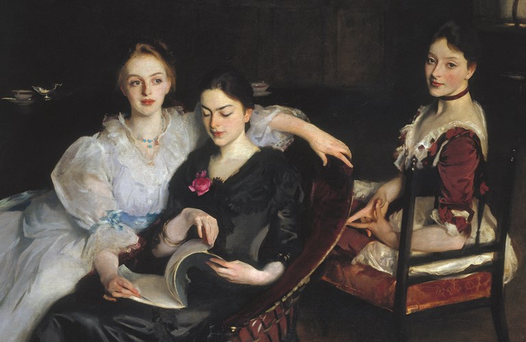 An oil painting of three women in formal Victorian dress. They are sitting informally next to each other - two women are sharing a chair and looking at a book, and the third woman is sitting on a chair behind them. The painting has a dark background, with the outline of a dresser on which sits a silver jug and a porcelain bowl. 
