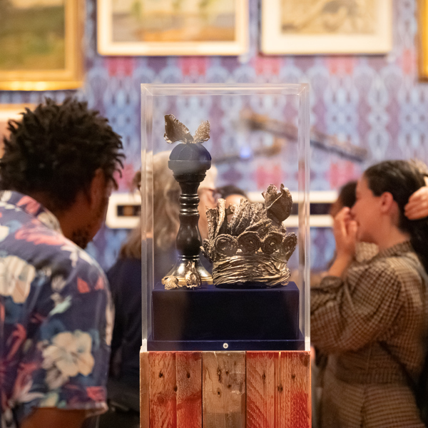 A visitor looking at objects in a disspaly case in an art gallery