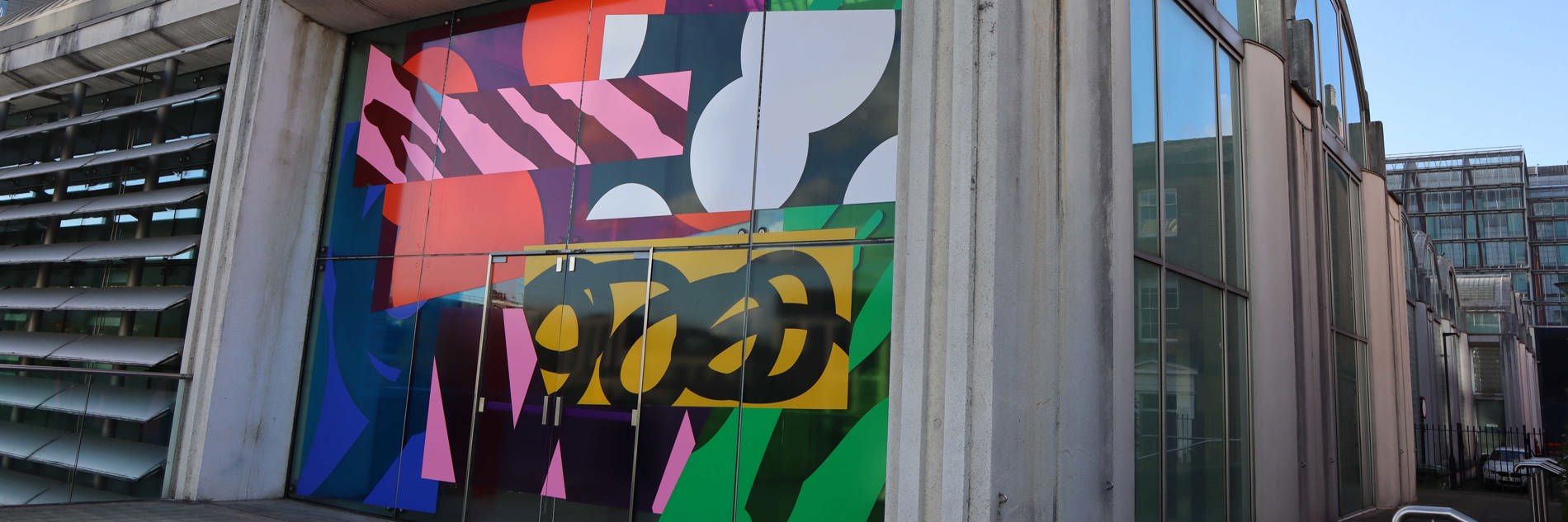 Exterior of Millennium Gallery featuring a bright, abstract design made from vinyl covering the window.