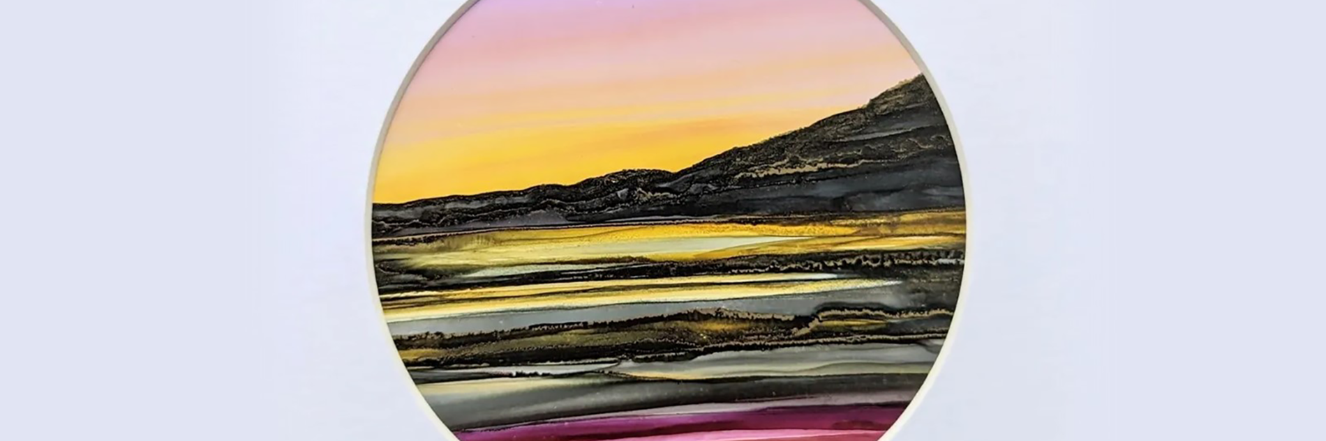 A landscape created with alcohol inks, using greens, reds and oranges.  The picture is mounted with a circular frame.