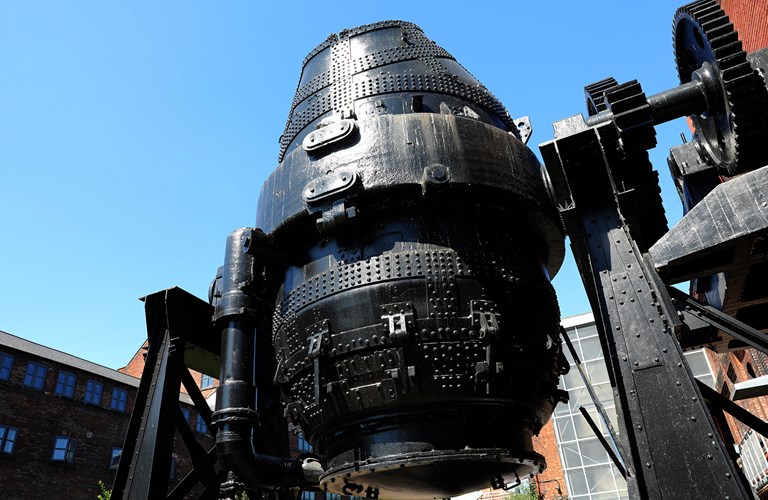 A view of a decommissioned Bessemer Converter against a backdrop of the Kelham Island Museum