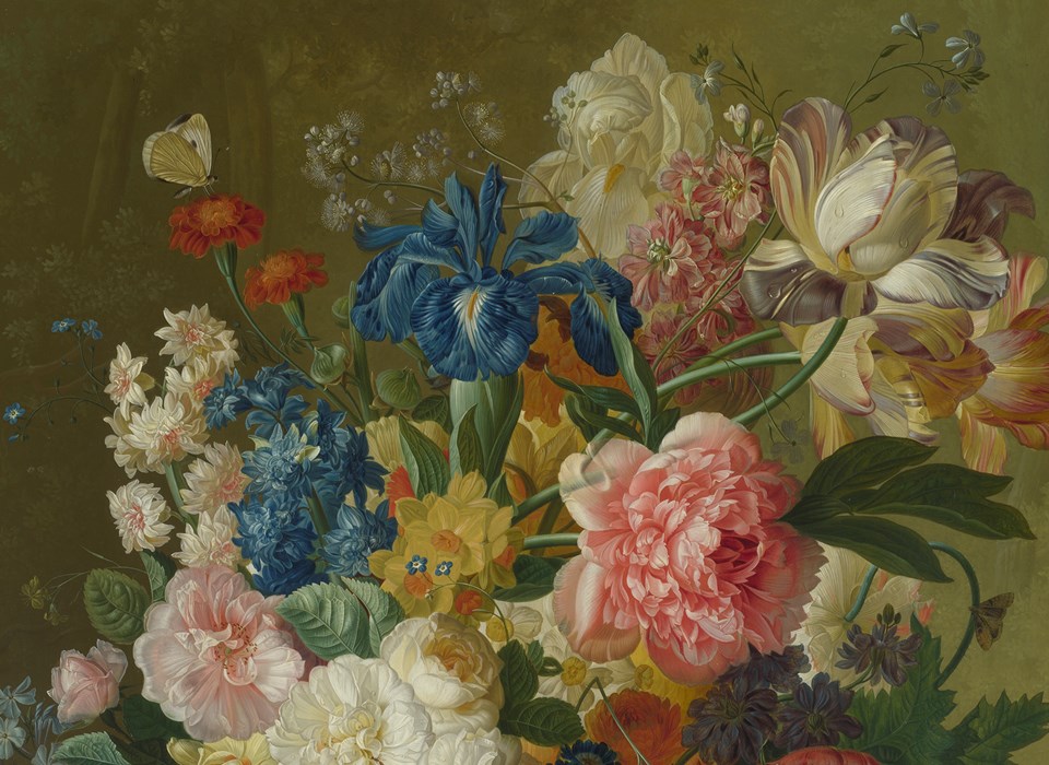 A teeming array of flowers including pink carnations and blue irises arranged in a vase against a muted green background