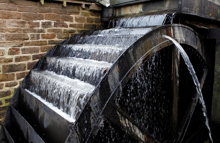 A waterwheel with water running over it.