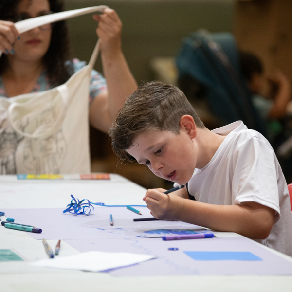 A child drawing at a table during an art activity