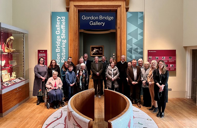 A group of people gathered in front of the entrance to the Gordon Bridge Gallery at Weston Park Museum.  