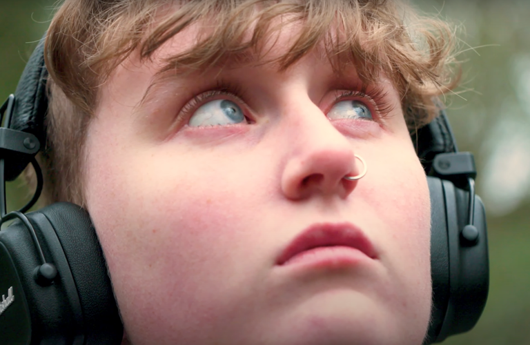 Close-up of a face of a young person wearing headphones.