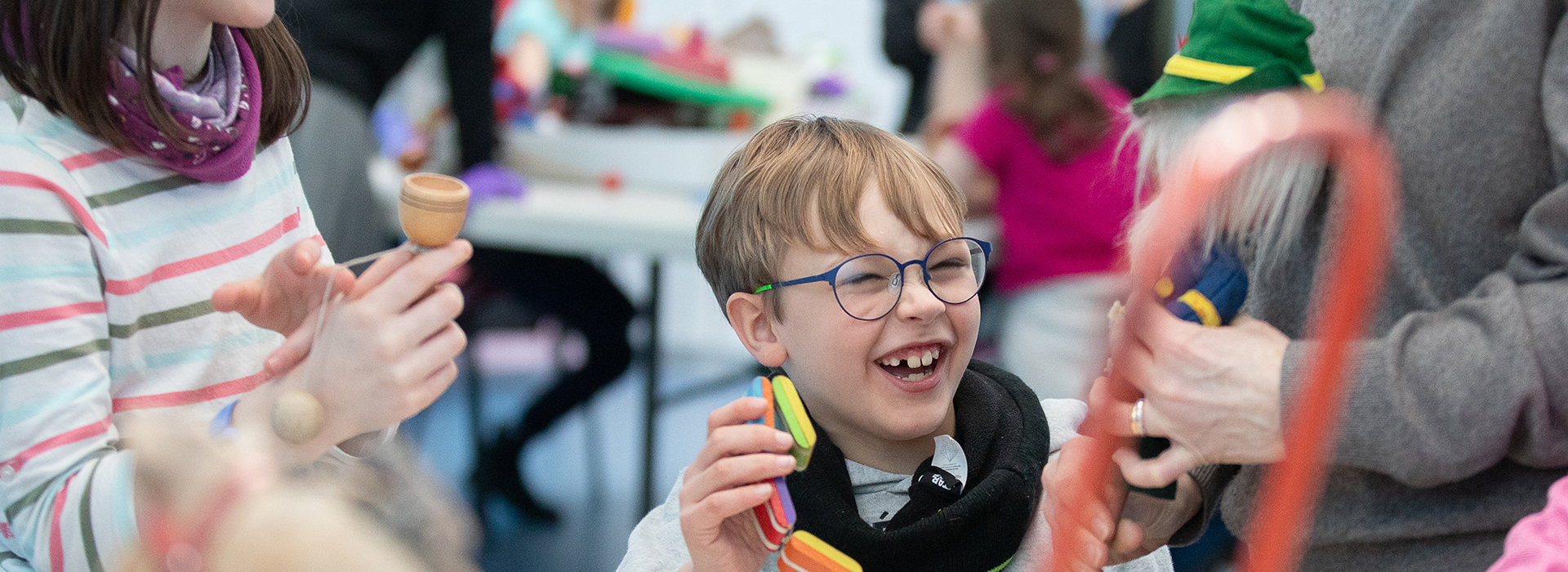 A child laughing while taking part in a schools workshop.