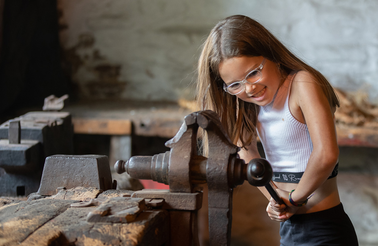 A young visitor tries a historic bench vice at Abbeydale Industrial Hamlet.