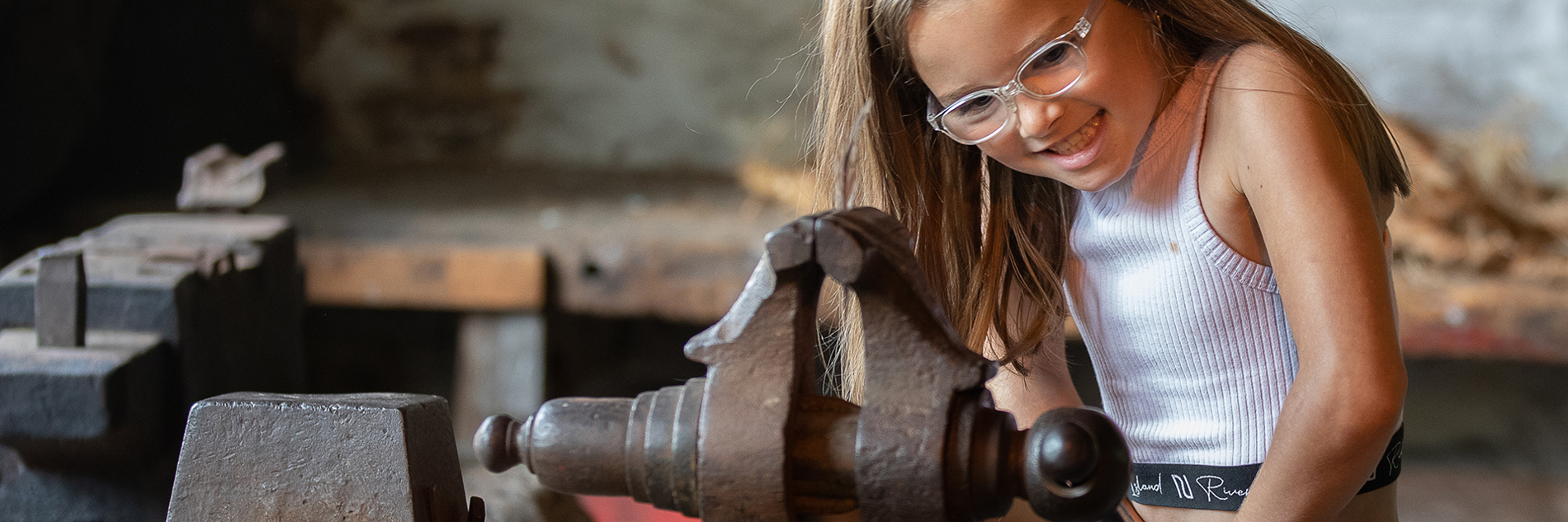 A young visitor tries a historic bench vice at Abbeydale Industrial Hamlet.