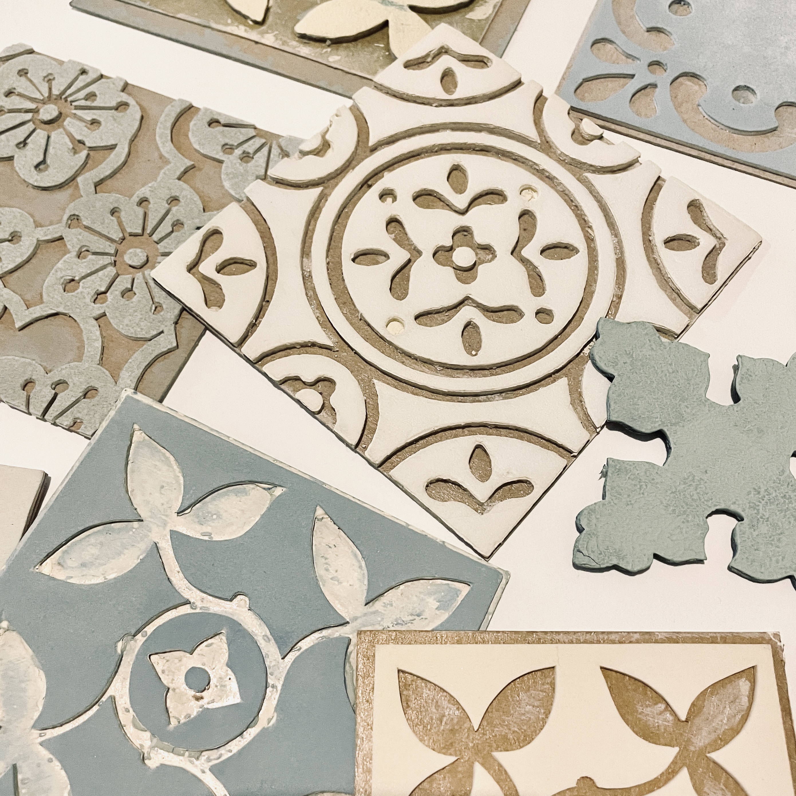 A selection of hand-block printing tiles, they're square shaped with graphic floral patterns.