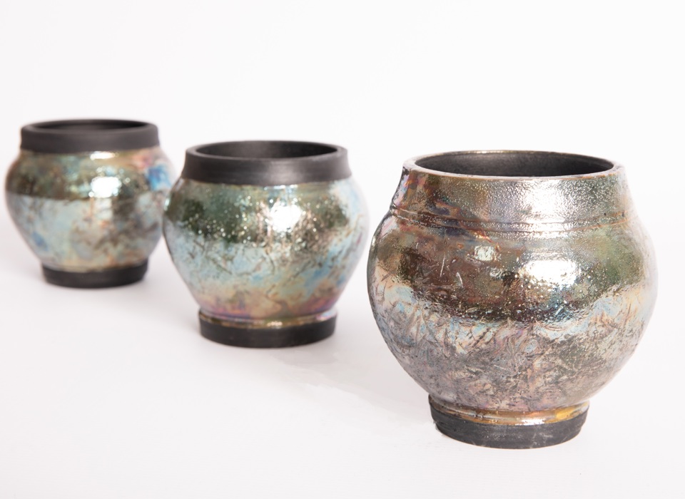Three vases with a hammered, shiny surface. 