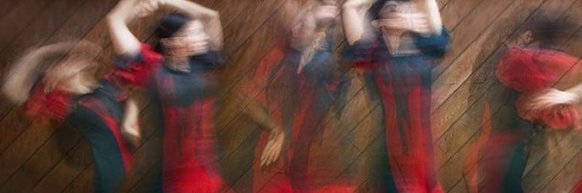 A blurred composite image of 5 women dancing against a wooden flooring background. They are wearing red and black frilled dresses and are twisting their arms above their heads