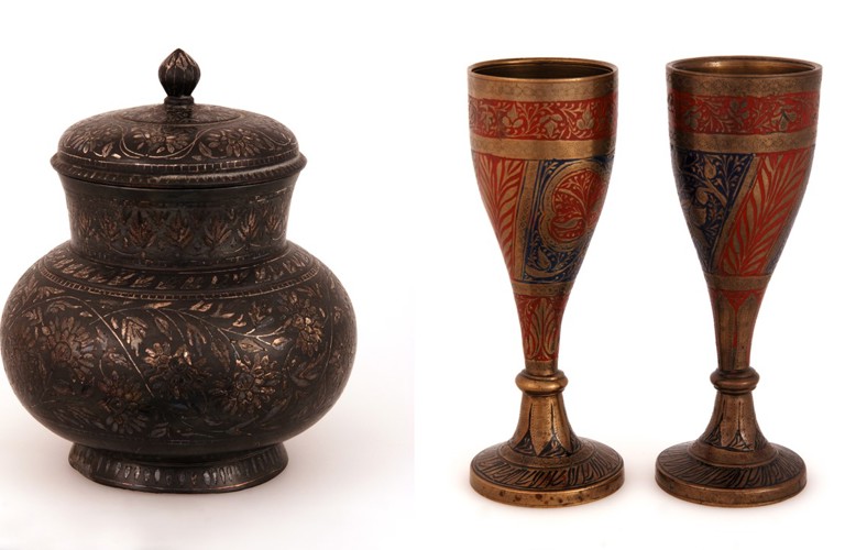 A photograph of two examples of South Asian metalwork against a white background. One is a brown/bronze lidded jar, the other is two golden drinking cups decorated with blue and red.