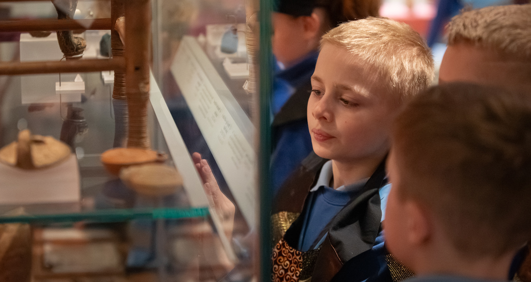 A group of children looking in a display case. 