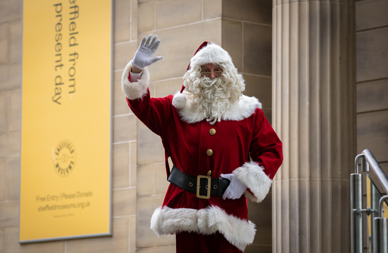 A photograph of Santa waving outside of Weston Park Museum