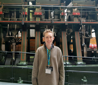 An adult standing in front of the River Don Engine