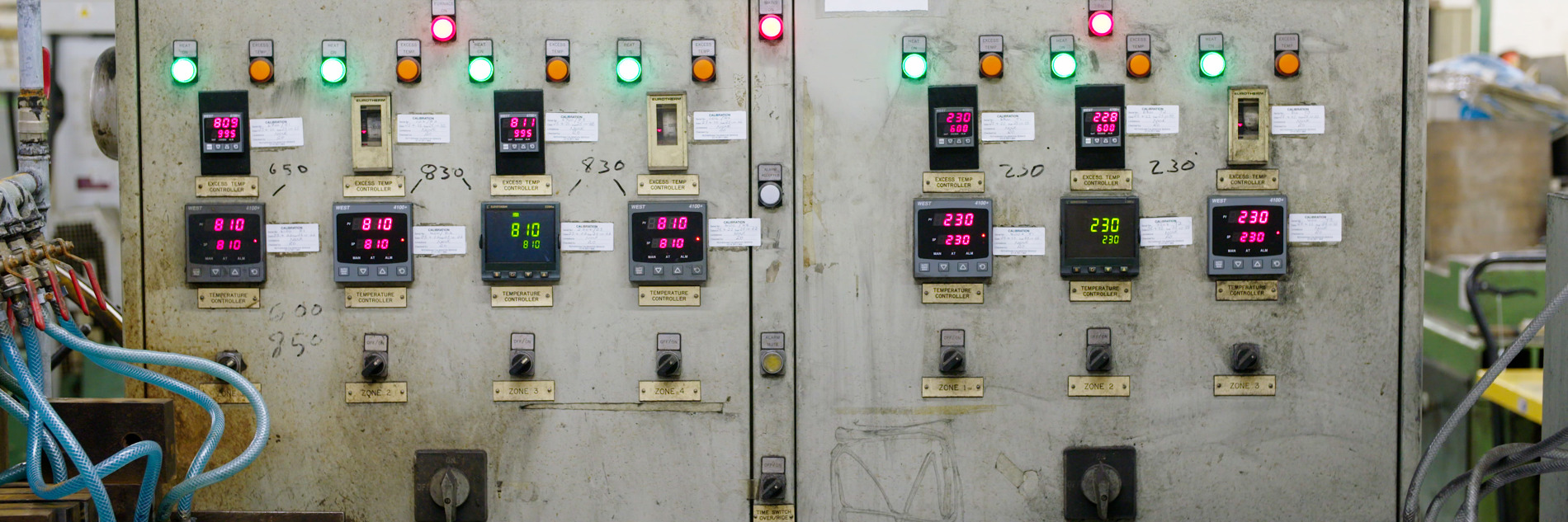 A photograph of a large piece of machinery with several wires and cables in front it. The words "hardening furnace" and "tempering furnace" are on the front of the machine. There are also several lights, digital displays and switches. 