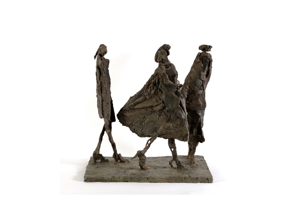 A photograph of a sculpture of three people caught in a walking motion. They are loosely sculpted in a brown medium