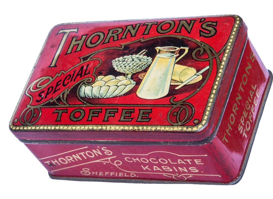 A red tin with the words Thornton's Special Toffee in gold. There is an illustration on the lid of a white jug of milk, a bowl of eggs and a plate of butter with a knife.