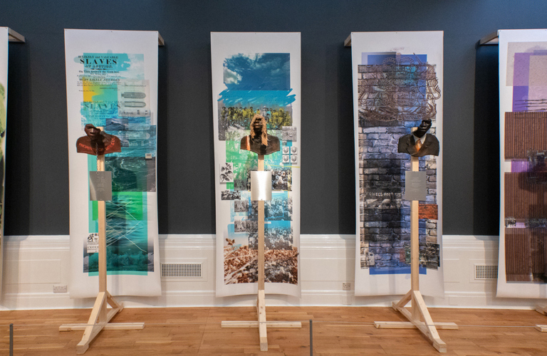 Five scuptures of shoulders and partial faces, all against collages themed around black history.