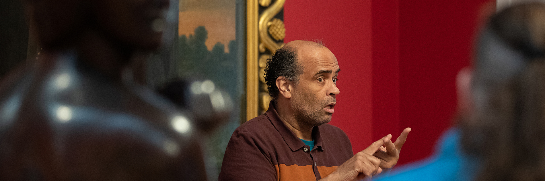 A tour guide using BSL communicates with a group in a gallery.
