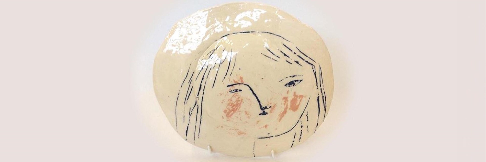 Ceramic glazed plate with a hand-drawn illustration of a face