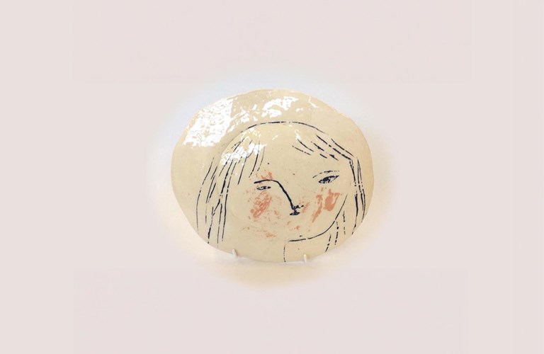 Ceramic glazed plate with a hand-drawn illustration of a face