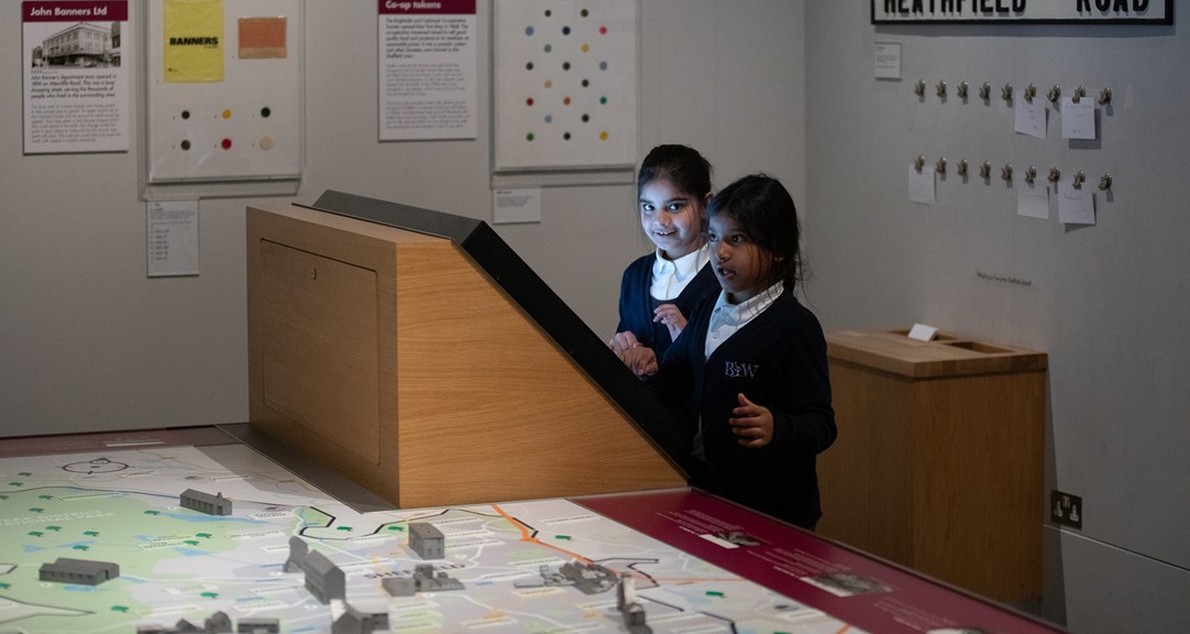 Two primary school students looking at screen set on a table with a map. 