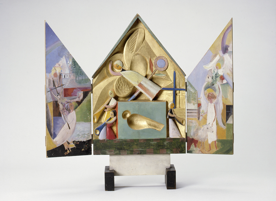 An open small altar. The open centre section features an stylised bird in gold. The interiors of the doors either side feature multicoloured illustrations. 