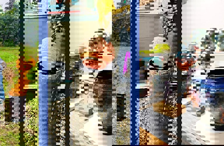 A composite of 3 images (L-R): An adult outside wearing protective clothing putting fuel on a fire; a pot being lifted with a utensil from a black container; glazed pots on plinths.  