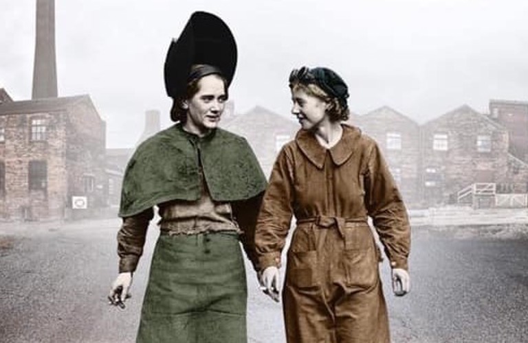 An old second world war photograph of two women walking side by side in conversation. Old factories have been imposed behind them.