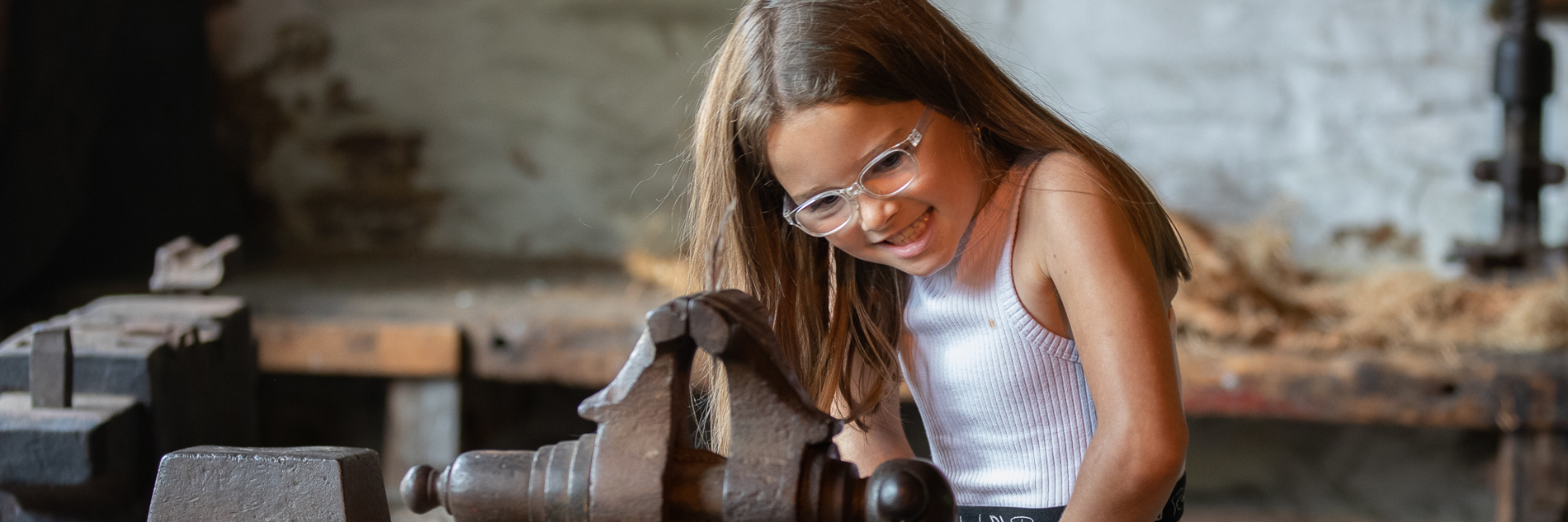 A young visitor tries a historic bench vice at Abbeydale Industrial Hamlet.