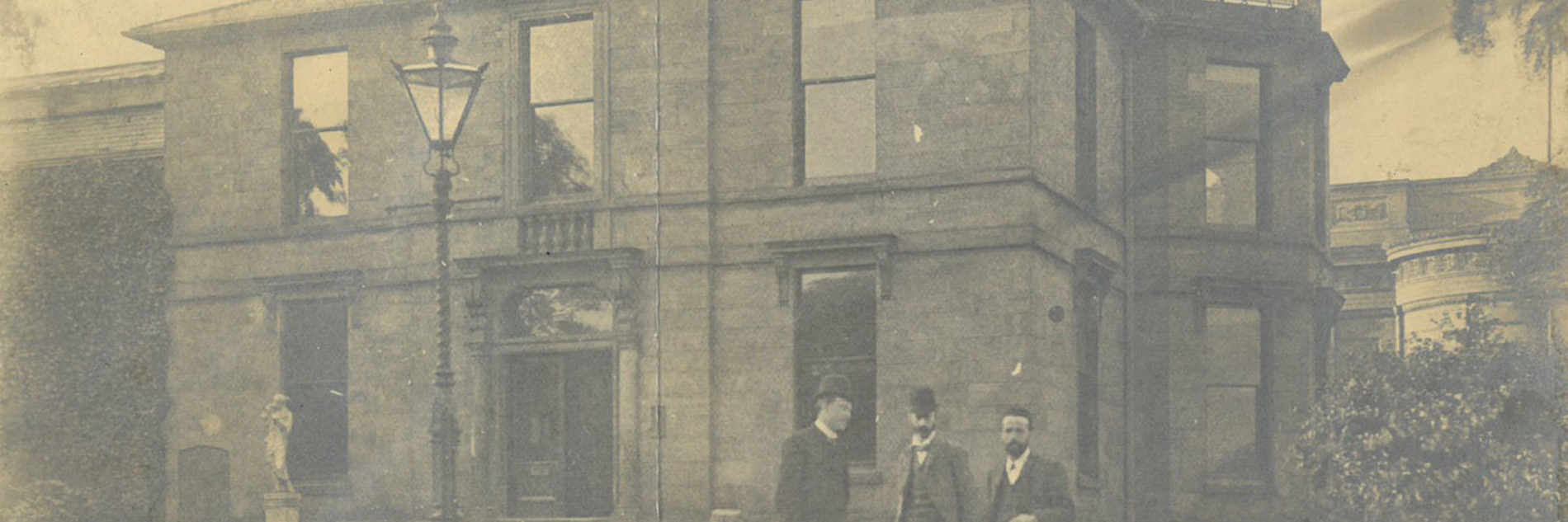 An old black and white photograph of three gentleman stood outside Weston Park Museum, all smartly dressed.