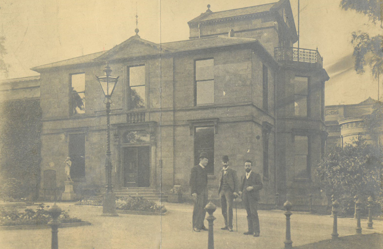 An old black and white photograph of three gentleman stood outside Weston Park Museum, all smartly dressed.