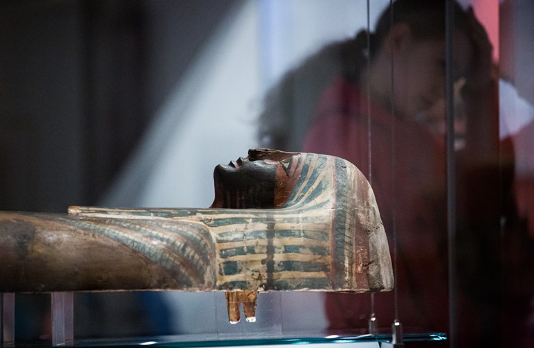 An Egyptian mummified person in a glass cabinet