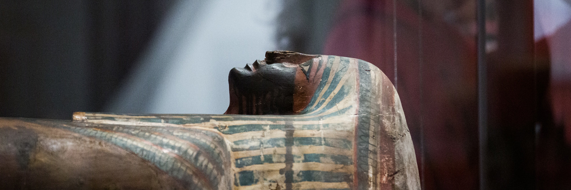 An Egyptian mummified person in a glass cabinet