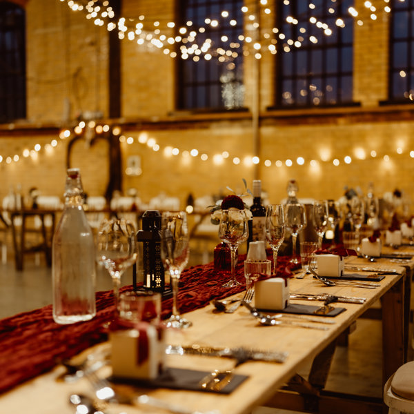 A photograph of the table settings for a wedding at Kelham Island Museum. There are twinkling lights in the background.