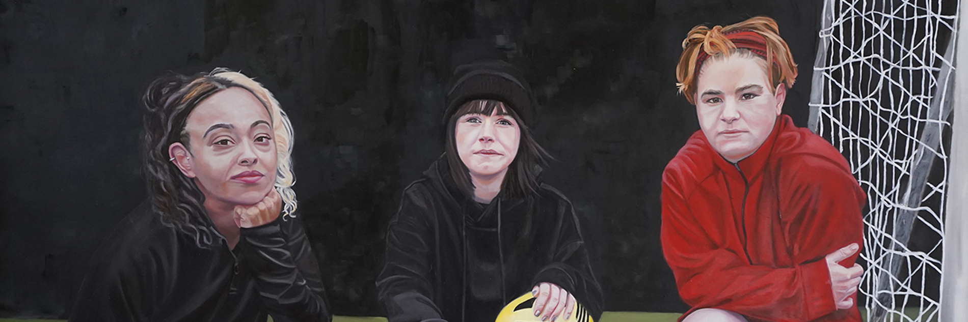 A painting of three teenage girls in football gear, all crouched next to the goal. The girl in the centre holds a yellow ball, all look directly out of the painting towards the viewer.