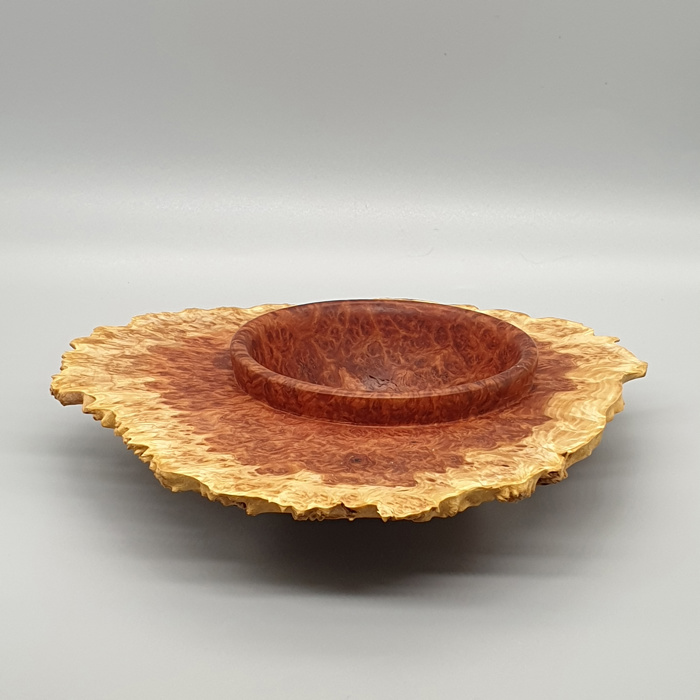 A photograph of a brown (possibly wooden) bowl with natural edges. 
